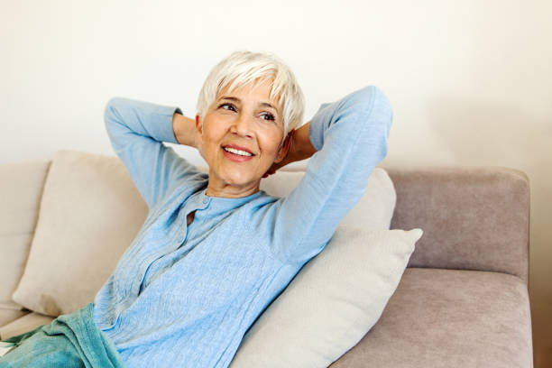 istock Woman having a daydream on the sofa relaxing with her head tilted back. 1401898120
