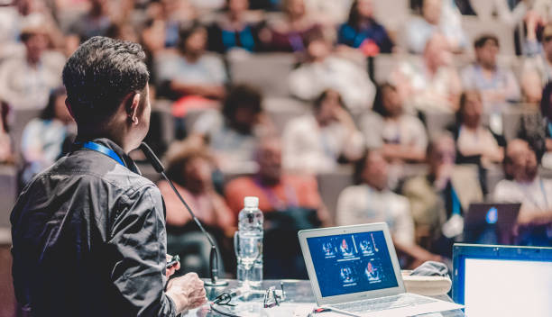 istock Rear View Of Speaker Giving Speech At Podium 1401898281