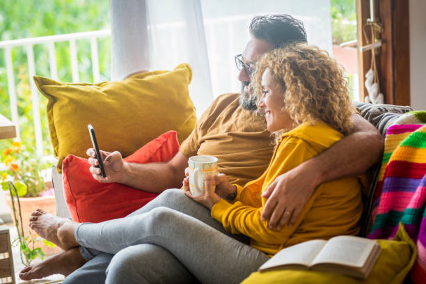 istock Smiling Couple Talking While Sitting On Sofa At Home 1401899156