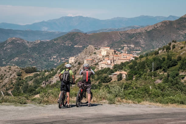 Two cyclists view Speloncato in Corsica stock photo