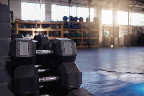 istock Stacked and piled heavy dumbbell weights arranged in empty gym with nobody during day with copyspace. Weightlifting equipment group organised in health and sports centre with no one. Healthy routine 1401903500