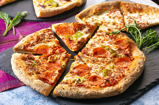 Italian steak pizza with tomato, arugula, microgreen and pesto sauce. Pizza Margherita. Ham and cheese pizza. Flat lay top-down composition on dark background.