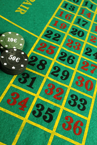 Game chips lie next to dice and glass of whiskey, gambling concept