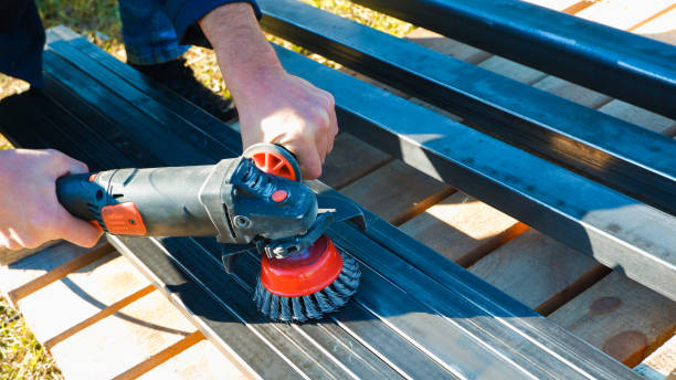 istock Hand with a turbine removes rust from metal. man using angle grinder 1401915109