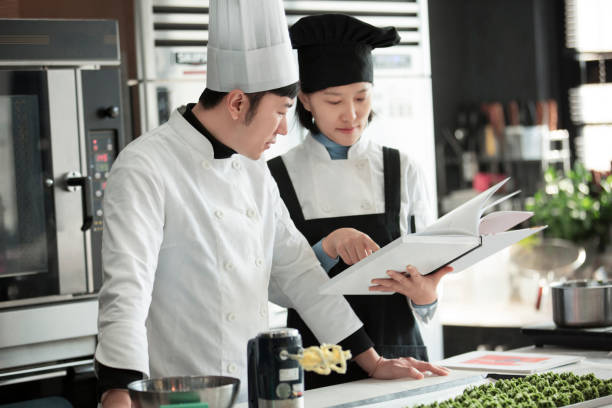istock Two young Chinese chefs working together to develop innovative desserts  - stock photo 1401916130