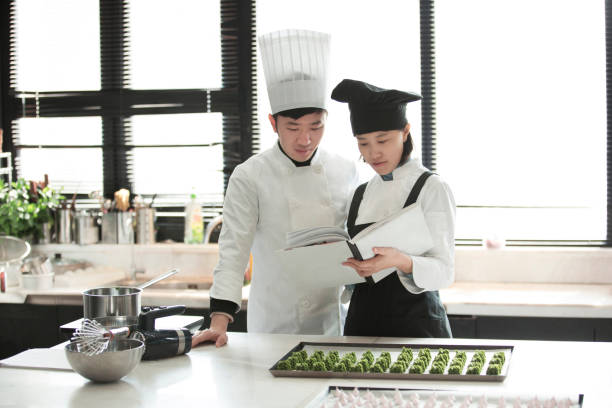 istock Two young Chinese chefs working together to develop innovative desserts  - stock photo 1401916144