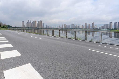 The roads and guardrails along the lake and the city buildings in the distance