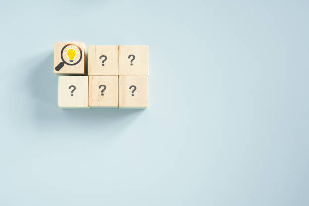 istock brighten lightbulb inside magnifying glass and question marks sign on wooden cube blocks for outstanding, leadership, smart people concept 1401918999