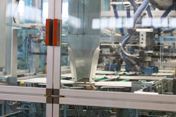 Close up detail of cartographic industrial machinery at work in a production line, conveyor belts are visible, no people are present.