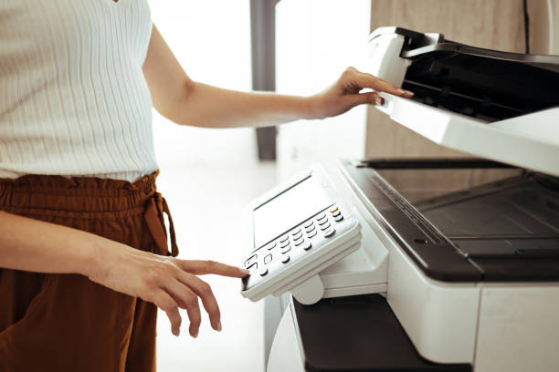 istock Young businesswoman using copying machine 1401920561