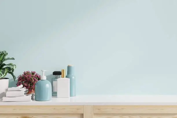 Photo of Accessories on white shelf in bathroom interior on blue wall.