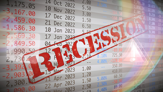 Side view on a financial spreadsheet with the word recession in red and lens flare overlay