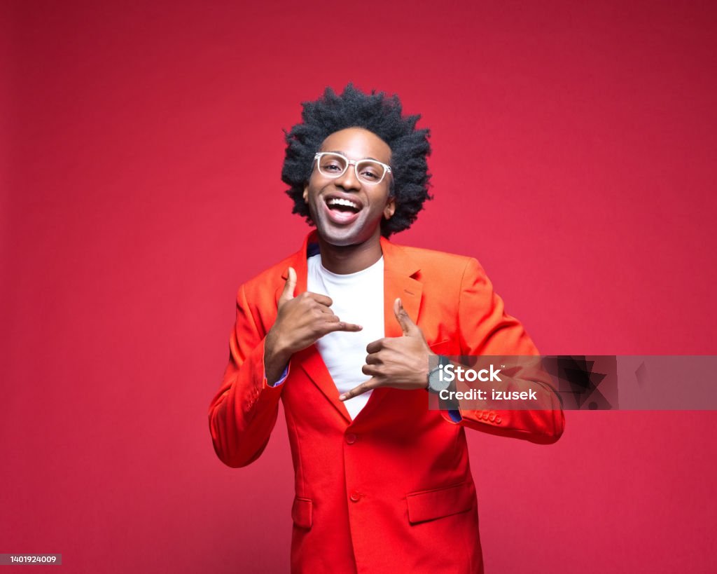 Businessman enjoying while dancing Portrait of businessman in red blazer laughing while dancing against colored background Cut Out Stock Photo