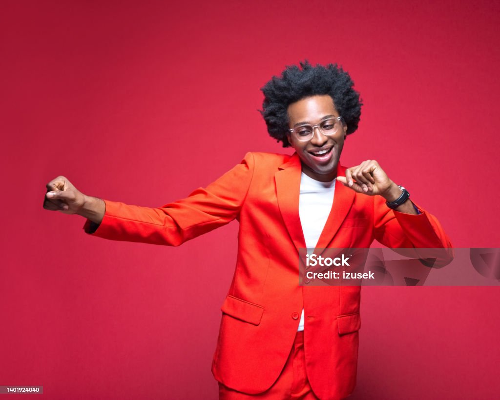 Businessman in red blazer enjoying while dancing Happy businessman in red blazer enjoying while dancing against colored background African-American Ethnicity Stock Photo