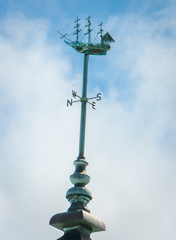 A ship weathervane atop the bright white tower of the City Hall and Arts Center in Hamilton, Bermuda