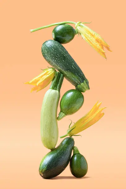 Photo of Balance with green zucchini vegetables on beige background. Healthy food and life balance concept.