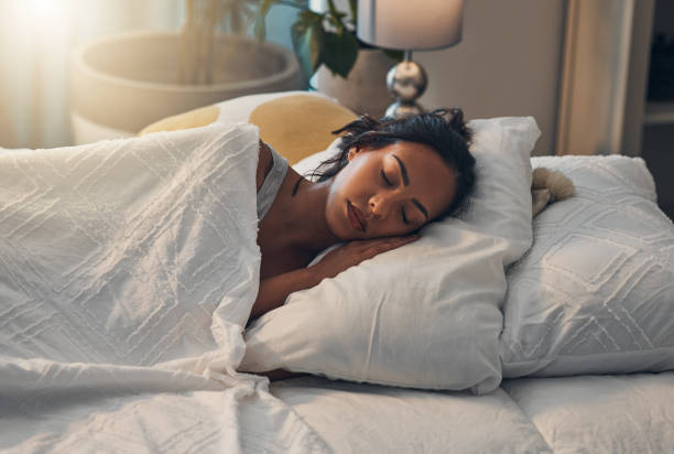 istock A beautiful young mixed race woman sleeping in a soft comfortable bed at home. One hispanic female feeling exhausted and resting in a comforting bed 1401927327