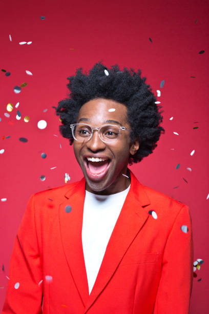istock Happy businessman with confetti against red background 1401927358