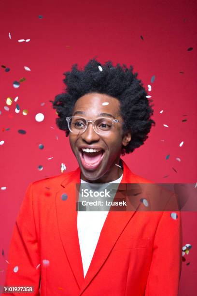 Happy Businessman With Confetti Against Red Background Stock Photo - Download Image Now