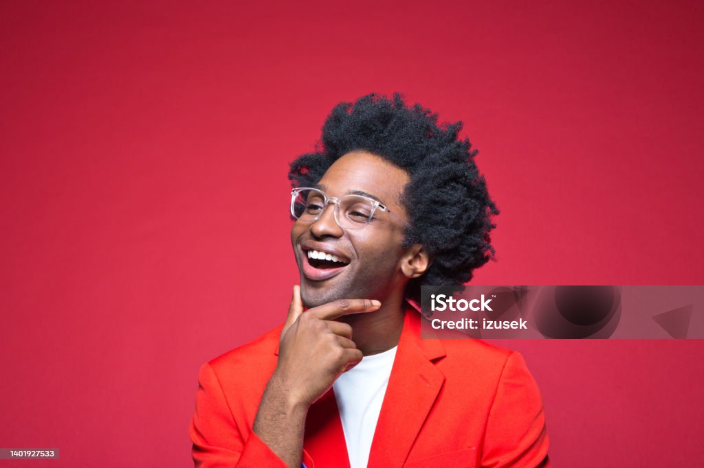 Happy businessman with hand on chin Happy businessman with hand on chin against red background Day Dreaming Stock Photo