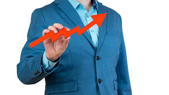 businessman holds a red arrow chart pointing up