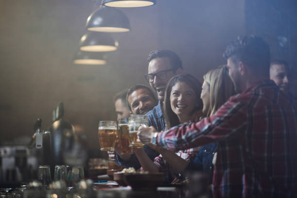 istock Cheerful friends toasting with beer during night out in a bar. 1401927821
