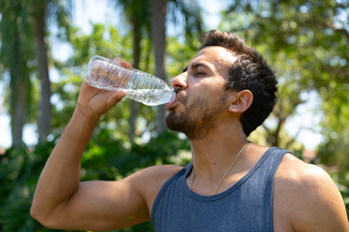 Portrait of amateur basketball player having water from bottle at outdoor court