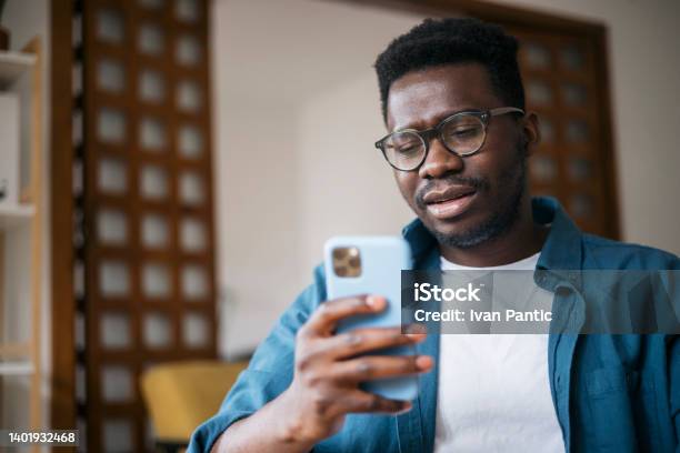 Reading About Bad News Using A Smart Phone Stock Photo - Download Image Now - Using Phone, Displeased, African Ethnicity