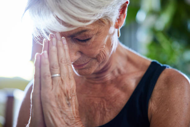 istock Senior woman meditating while practicing yoga at home 1401934447