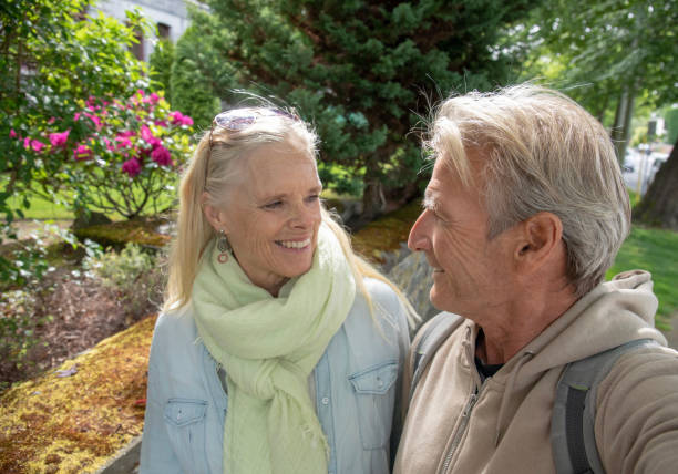 istock Mature couple walk along residential sidewalk 1401934703