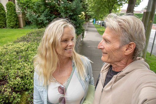 They smile at each other while communicating. Surrounded by lush foliage