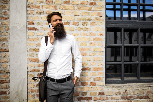 Bearded young man against brick wall