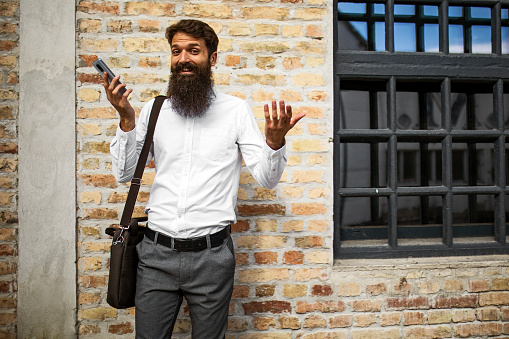 Bearded young man against brick wall