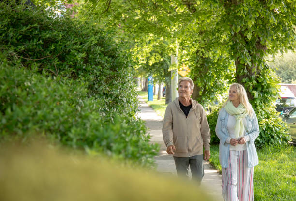 istock Mature couple walk along residential sidewalk 1401938202
