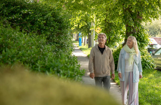 istock Mature couple walk along residential sidewalk 1401938211