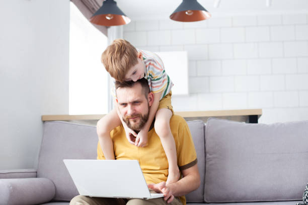 istock Father trying to work with his little son at home. 1401938483