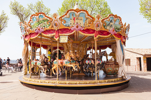 Adorable little girl on the playground. Toddler having fun on vintage carousel. Outdoor activities for small kids
