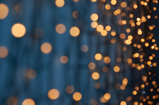 Low key photography of defocused golden lights (bokeh) on a dark blue background. Great background for Websites, Christmas and many more. Native image size: 7952x5304