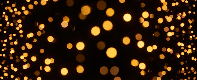 Photography of defocused golden lights (bokeh) on black background. Great background for Smartphones, Websites, Christmas and many more. Native image size: 13000x5304
