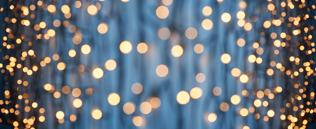 Photography of defocused golden lights (bokeh) on a dark blue background. Great background for Websites, Christmas and many more. Native image size: 13000x5304