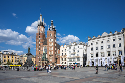 Krakow, Poland - May 9, 2022: main market square with saint mary´s church in the background in Krakow under blue sky, Poland