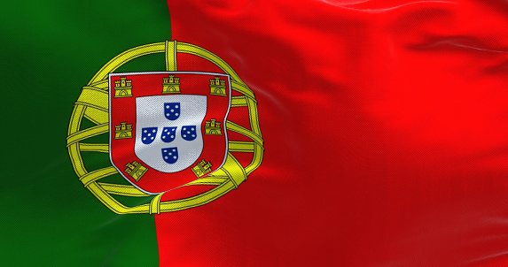 Detail of the national flag of Portugal waving in the wind on a clear day. Democracy and politics. European country. Selective focus