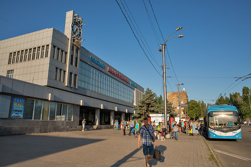 Mariupol, Ukraine - July 15, 2021: People in front of modern Passenger Railway Station facade.