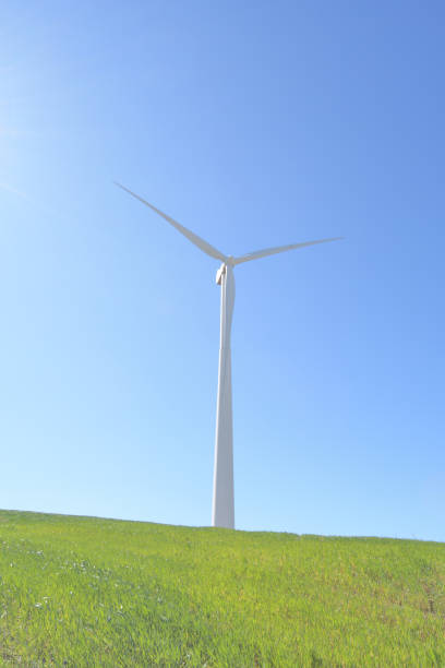青空の�ある晴れた日の丘の中で再生可能エネルギーの風力タービン - eolo ストックフォトと画像