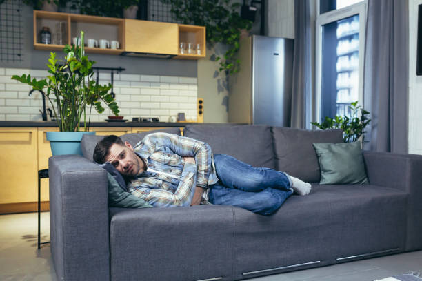 istock A young man is sleeping and lying on the couch at home. Tired, feeling bad, sick 1401950178