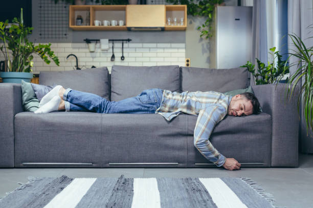 istock Depressed man tired after work sleeping on sofa at home 1401950273
