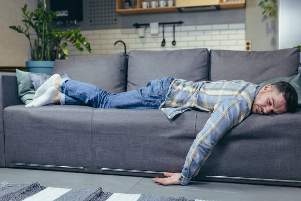 istock Depressed man tired after work sleeping on sofa at home 1401950281