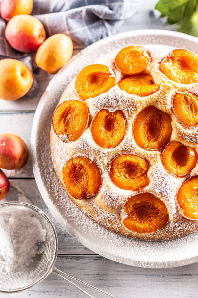 istock Delicious apricot cake sprinkled sugar powder on garden table. 1401952073