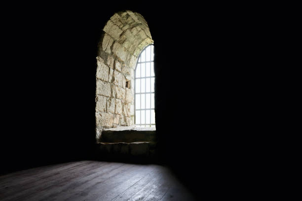 istock Sunlight enters the dark room through a barred window. 1401953238