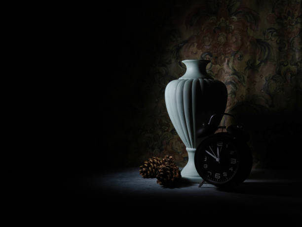 Retro, vintage urn, chiaroscuro in antique setting. Green ceramic with clock, pine cones. Time passing concept.